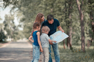 family with their children discussing the route on the map . family holiday concept