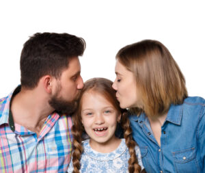 A happy family isolated on white background. Parents kissing baby